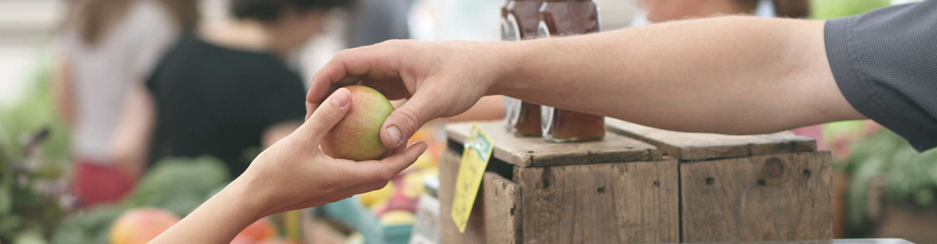 רוכל מעביר פרי ללקוח בסיור בשוק