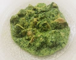 רביולי ברוטב ירוק על צלחת לבנה