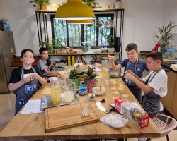 ילדים יושבים מסביב לשולחן ואוכלים