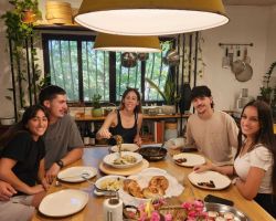 משפחה מצולמת ליד המנות שהכינו בסדנת בישול